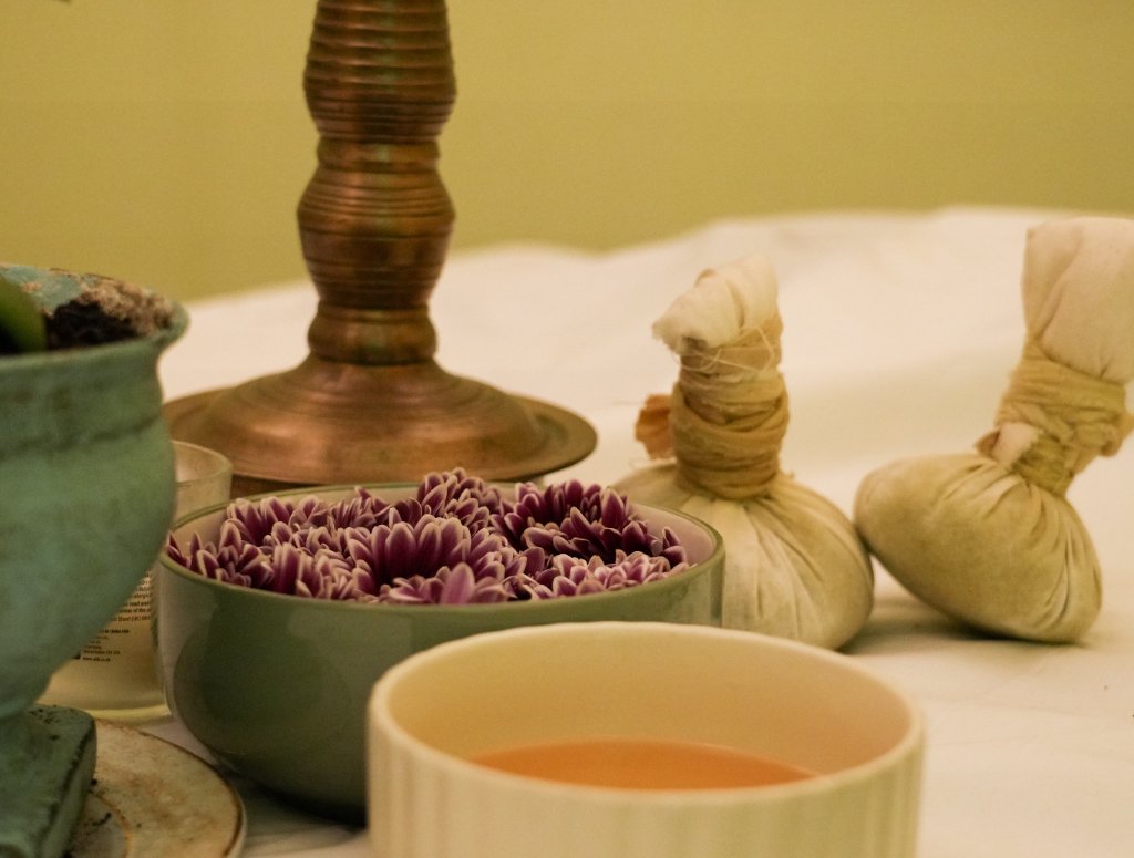 Spa wellness still life with chrysanthemums and herbal compresses