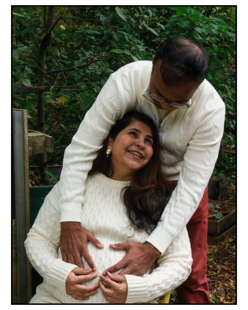 Couple sharing a joyful moment in garden maternity