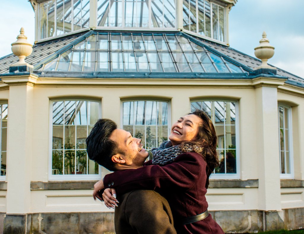 Couple laughing outside glasshouse