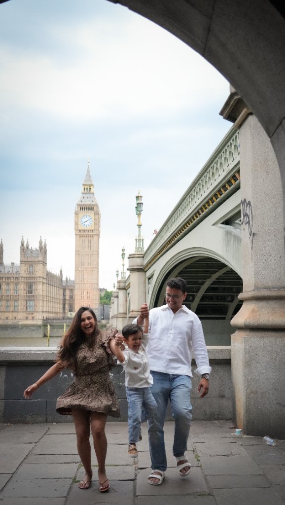 Family walking and lifting son in front of Big Ben