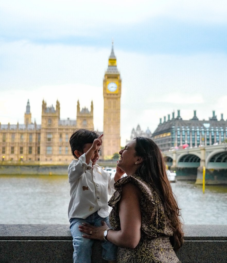 Mother and son pointing toward sky with Big Ben behind