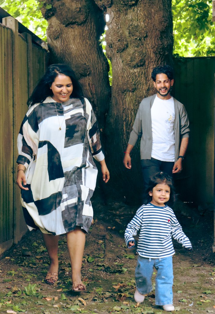 Family walking together by large tree in garden