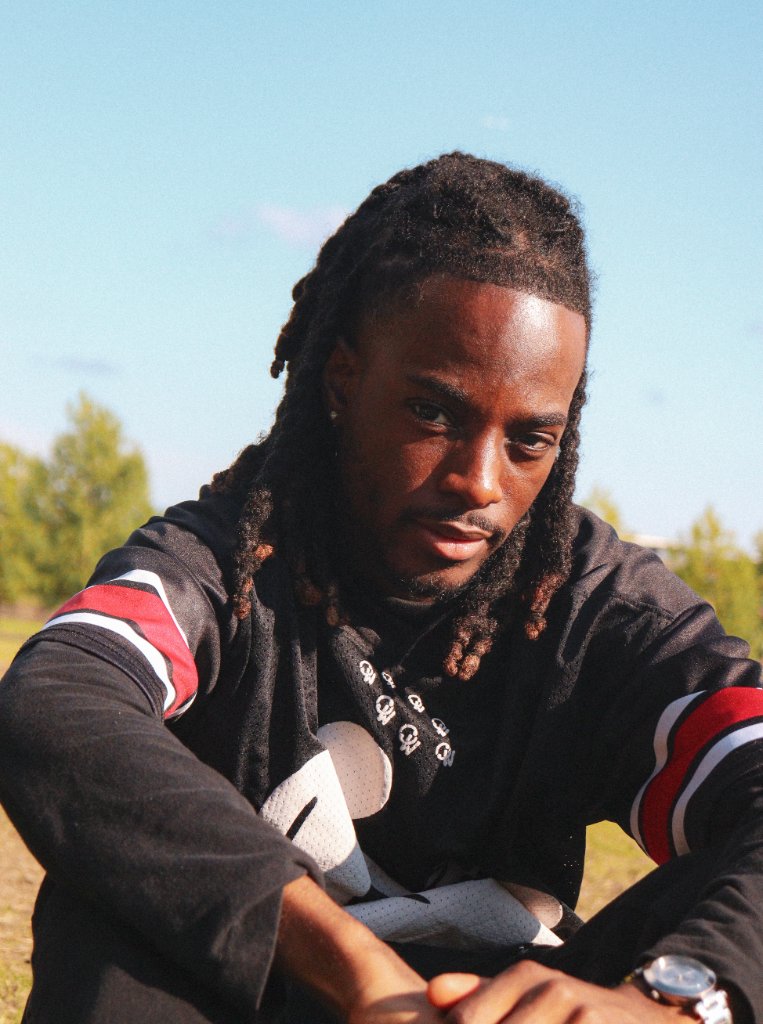 Portrait of man with dreadlocks outdoors in sunlight