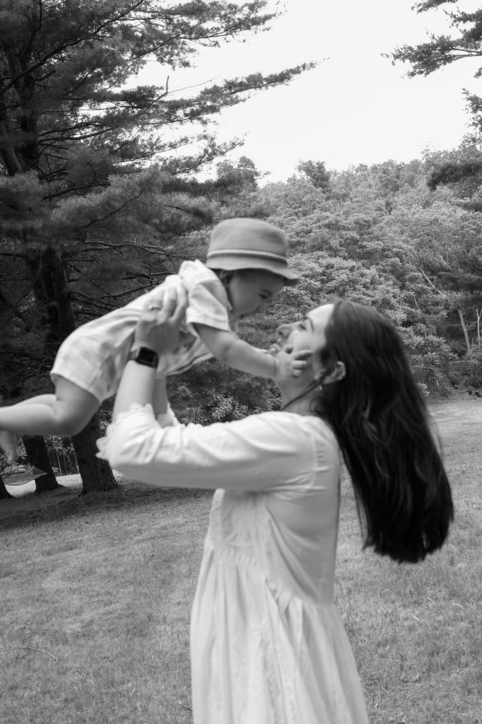 Black and white of mother lifting toddler in the air