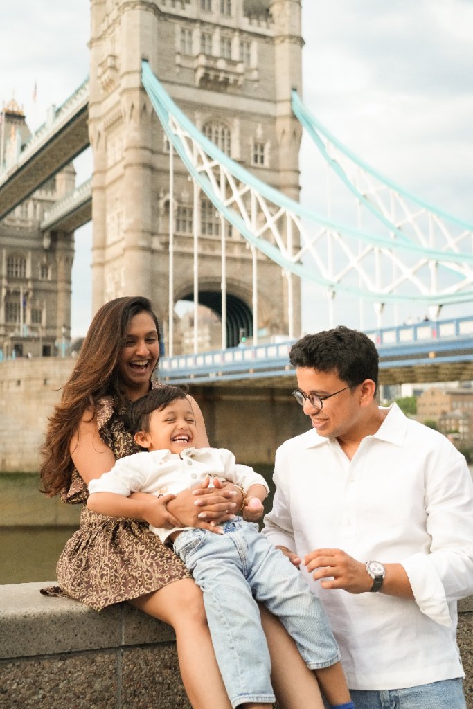 Family laughing together in front of Tower Bridge