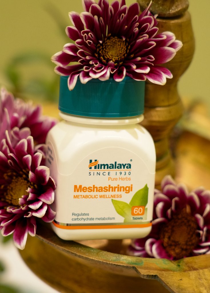 Himalaya Meshashringi supplement bottle surrounded by chrysanthemums