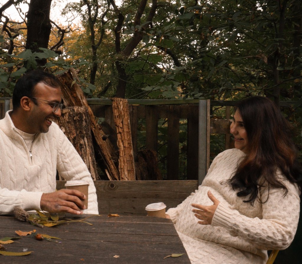 Couple laughing at outdoor table with autumn trees