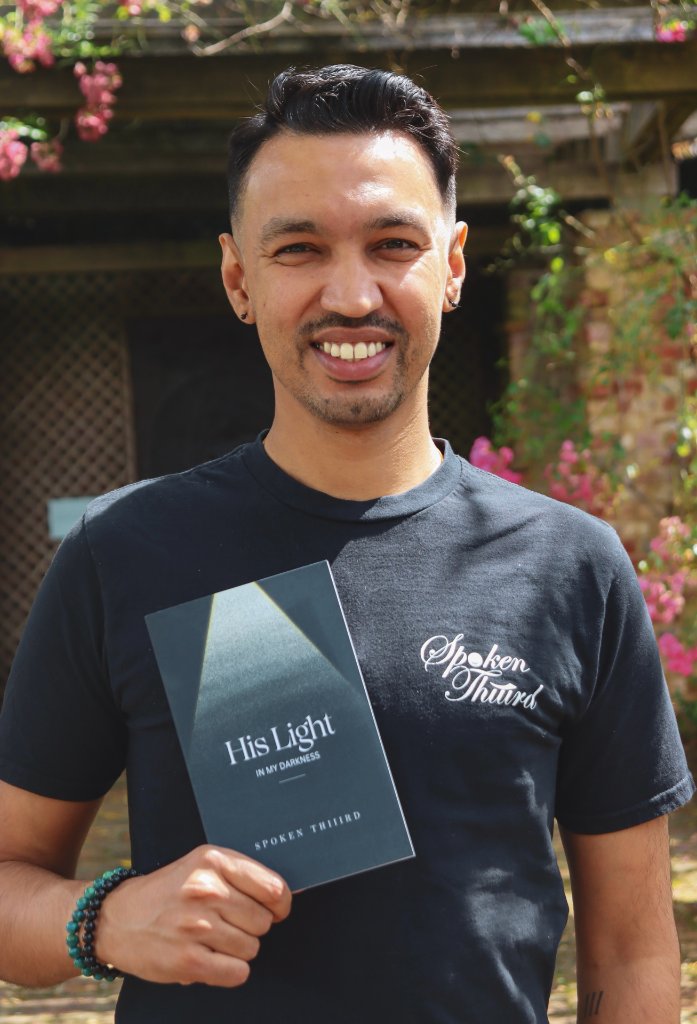 Kishan Shah holding His Light In My Darkness book
