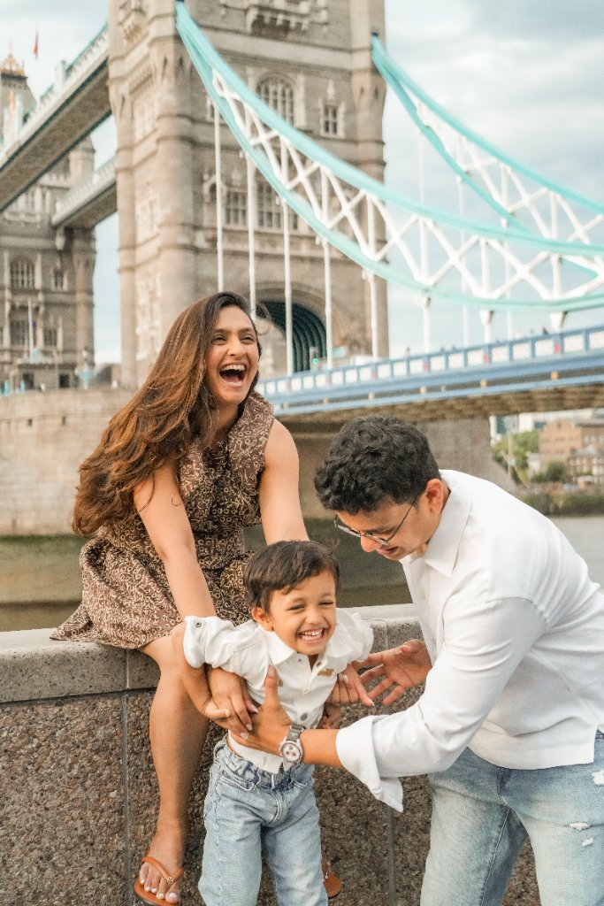 Family laughing together on Tower Bridge balustrade
