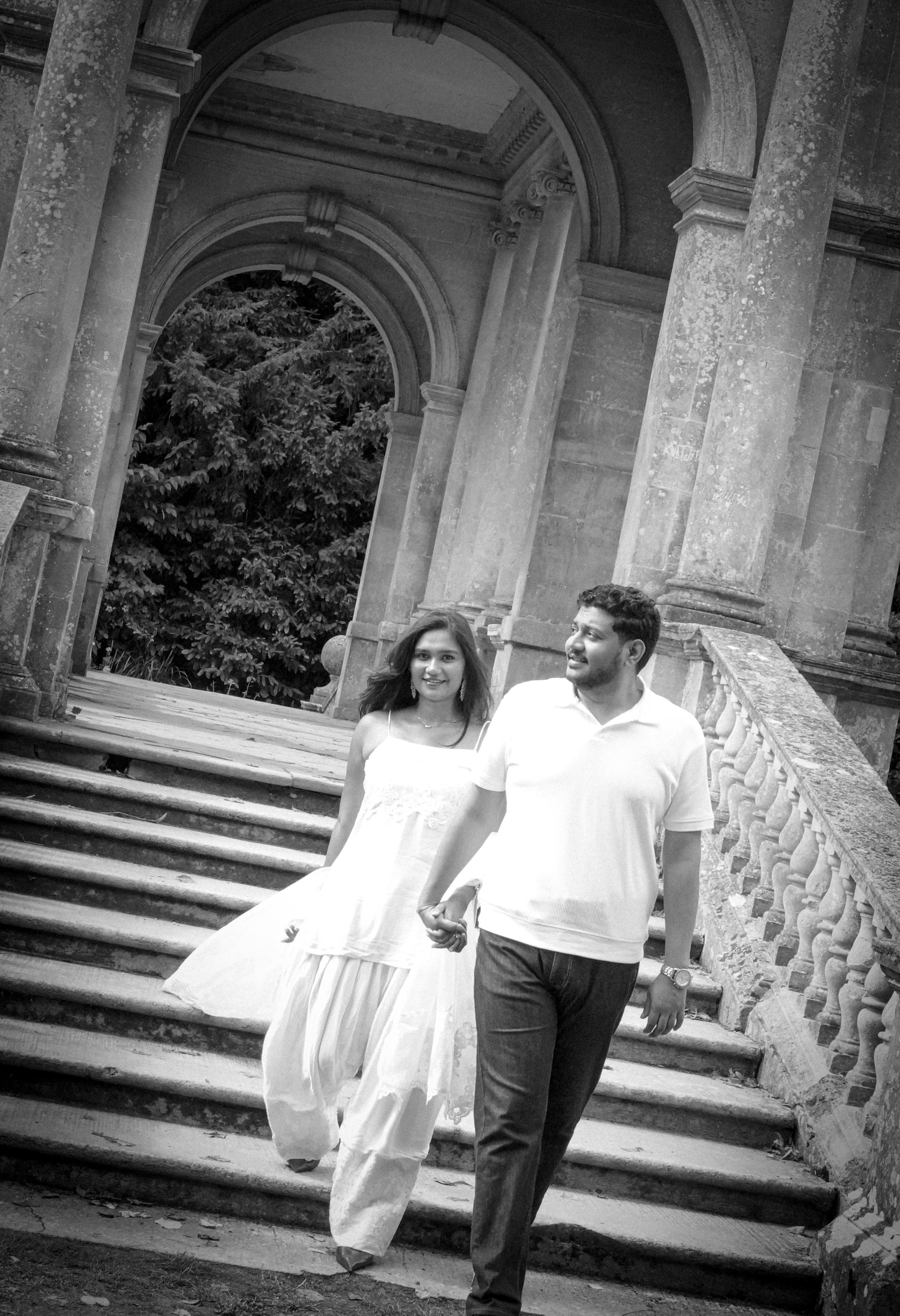 Black and white couple holding hands walking down stone staircase