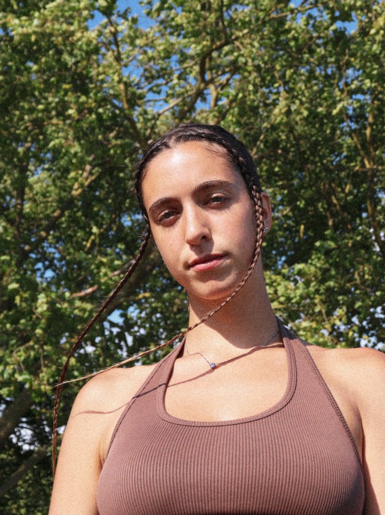 Portrait of woman with braids outdoors against trees