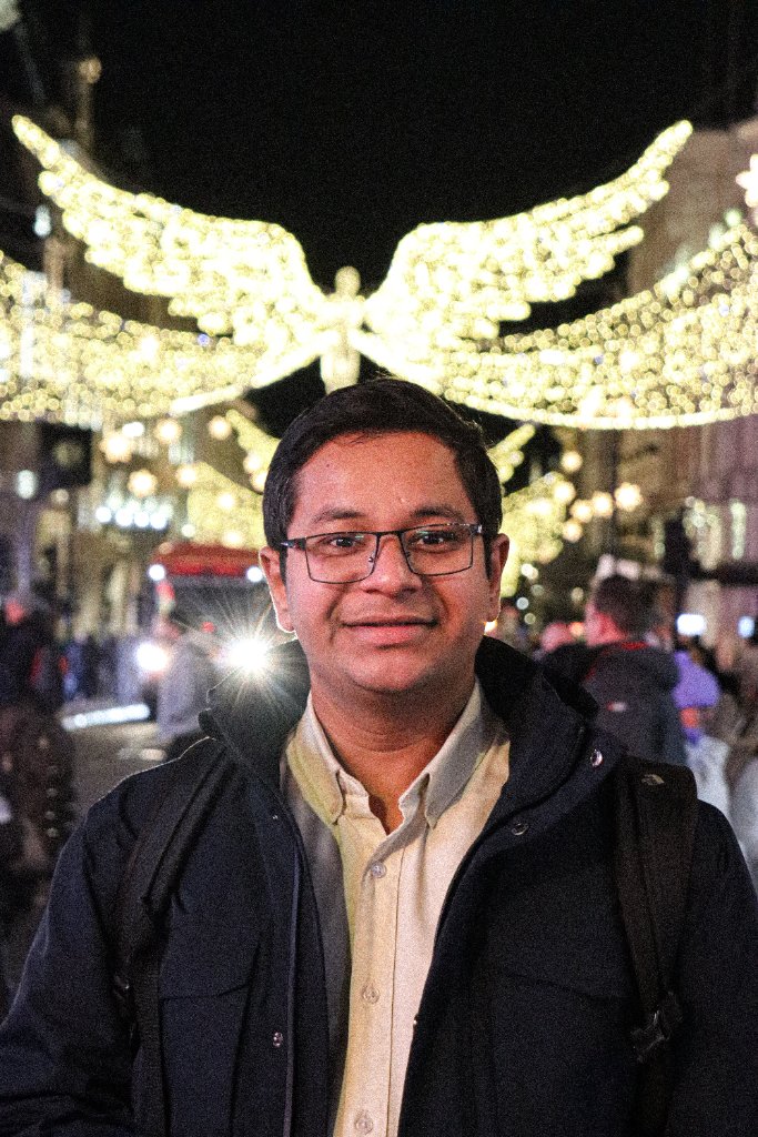 Portrait of man under Christmas lights on London street