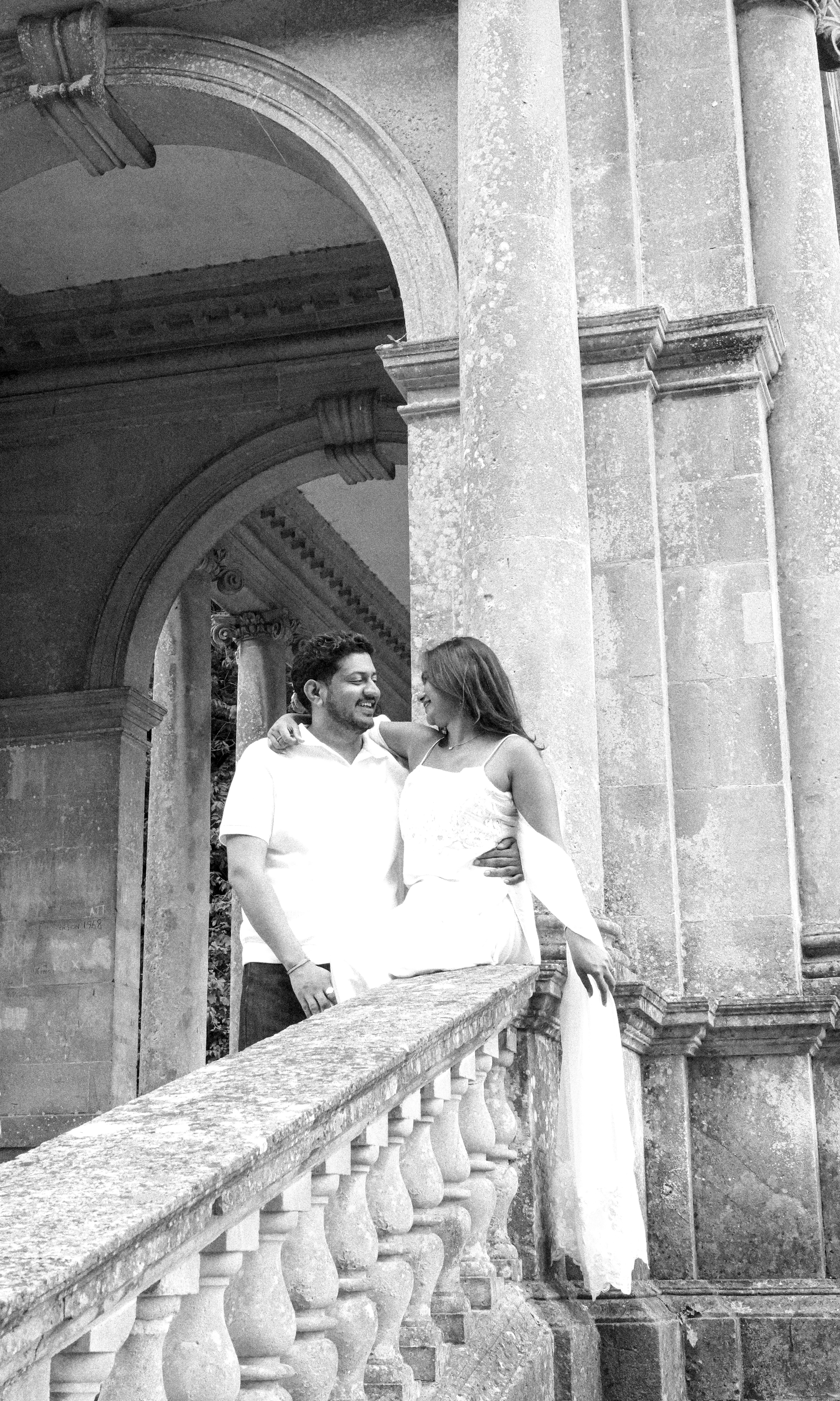Black and white couple on ornate stone staircase with flowing scarf