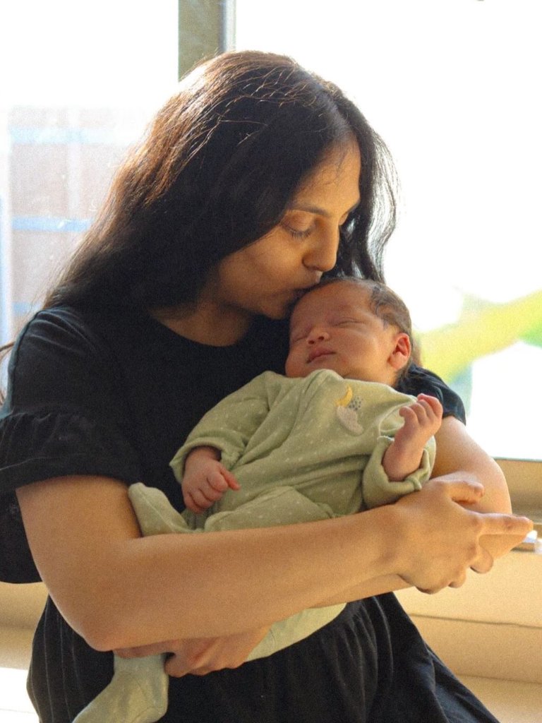 Mother kissing newborn baby