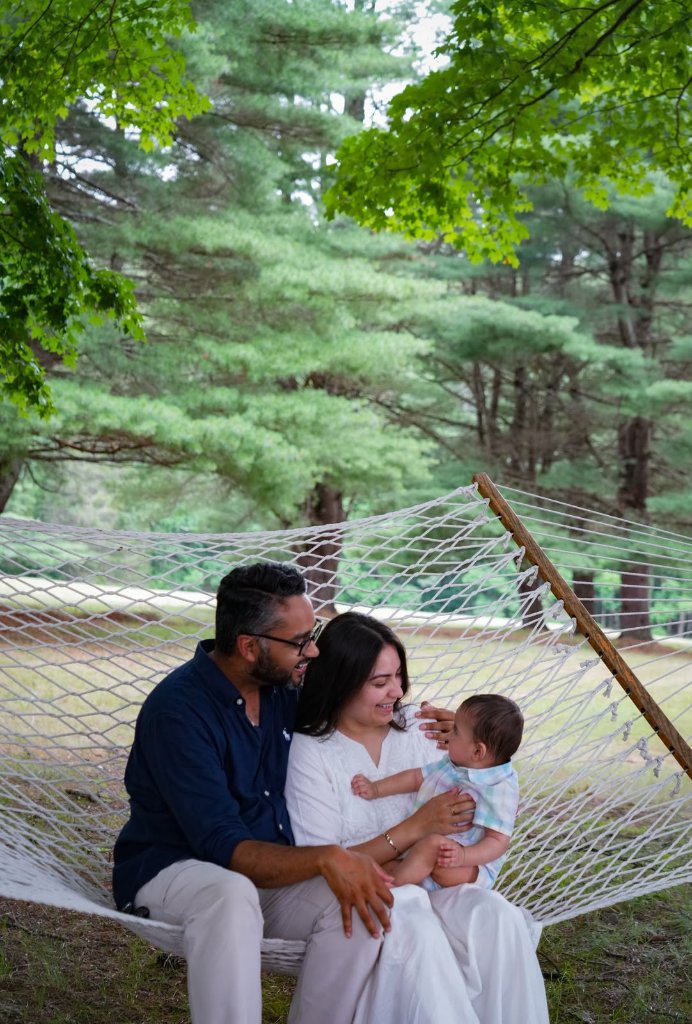 Family of three sitting on hammock in forest