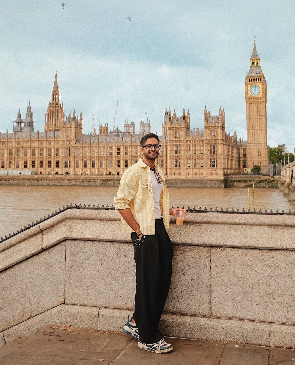 Young man with iced coffee on Westminster Bridge with Big Ben behind