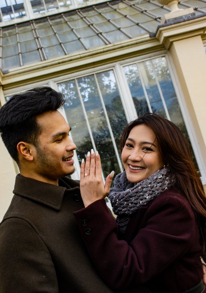 Couple showing engagement ring outside