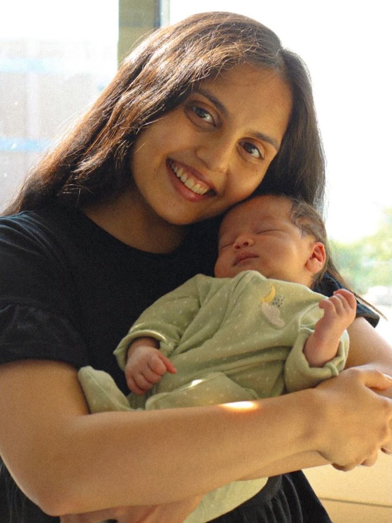 Mother smiling with newborn baby