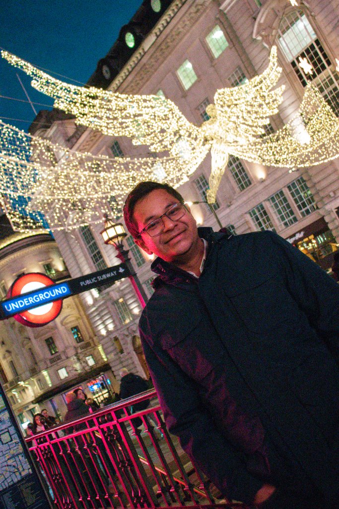 Portrait of man by London Underground with Christmas lights