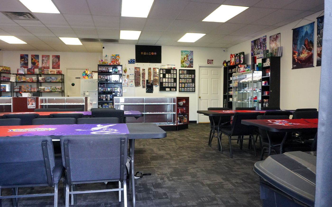 Inside CardFellas: play tables up front, display cases along the back
