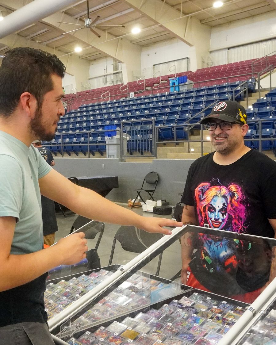 Shoppers talking with CardFellas staff across the display case