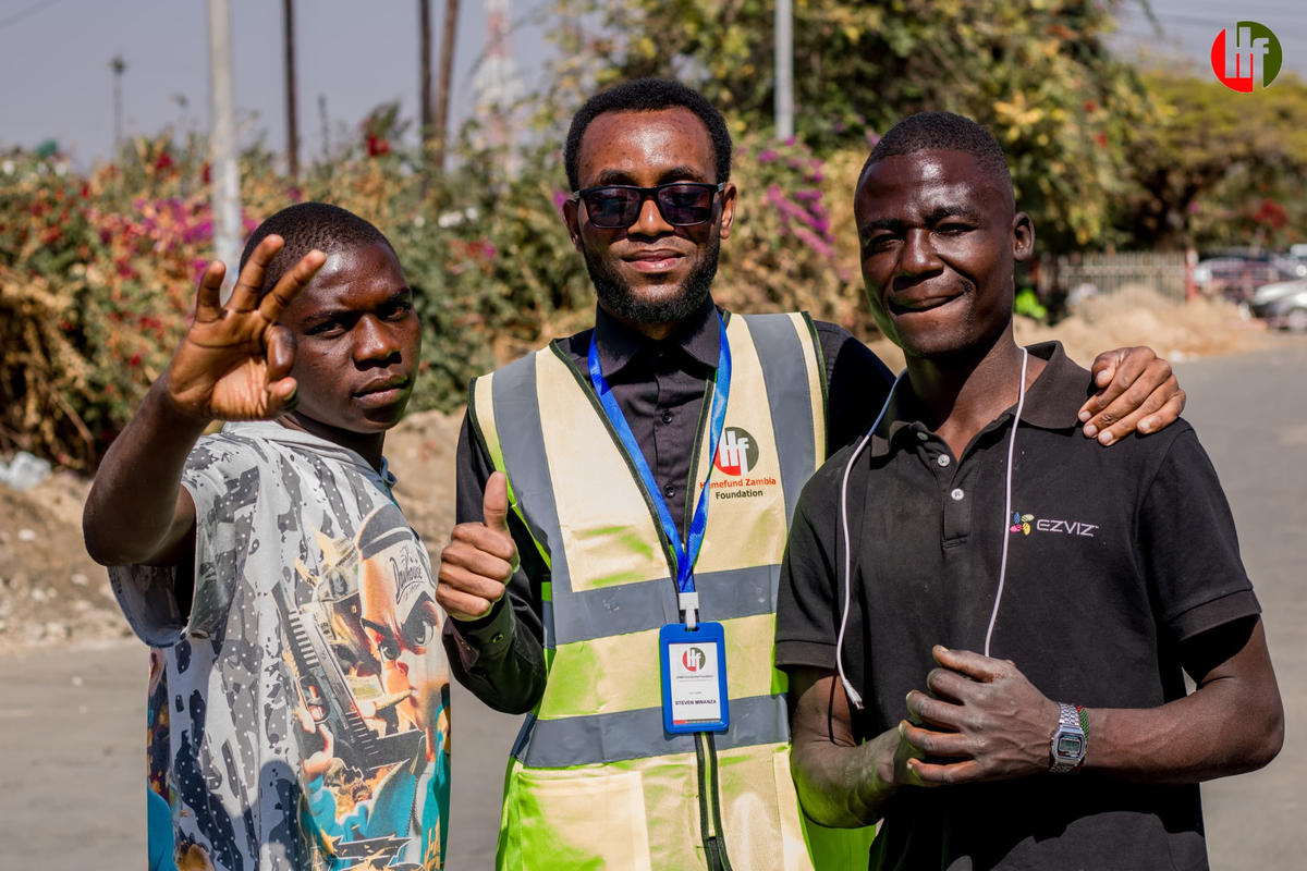 A volunteer with two young people outdoors