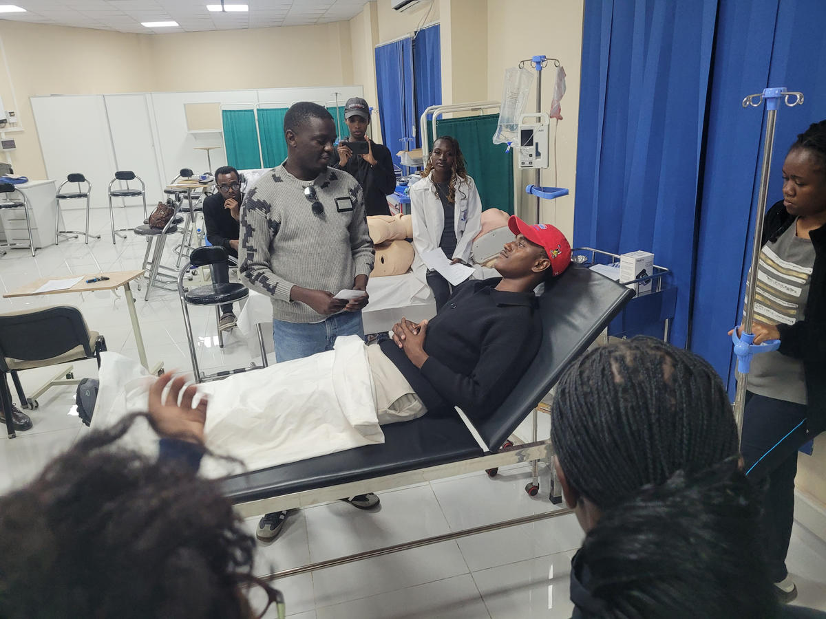 An instructor guiding a simulated patient exercise during training