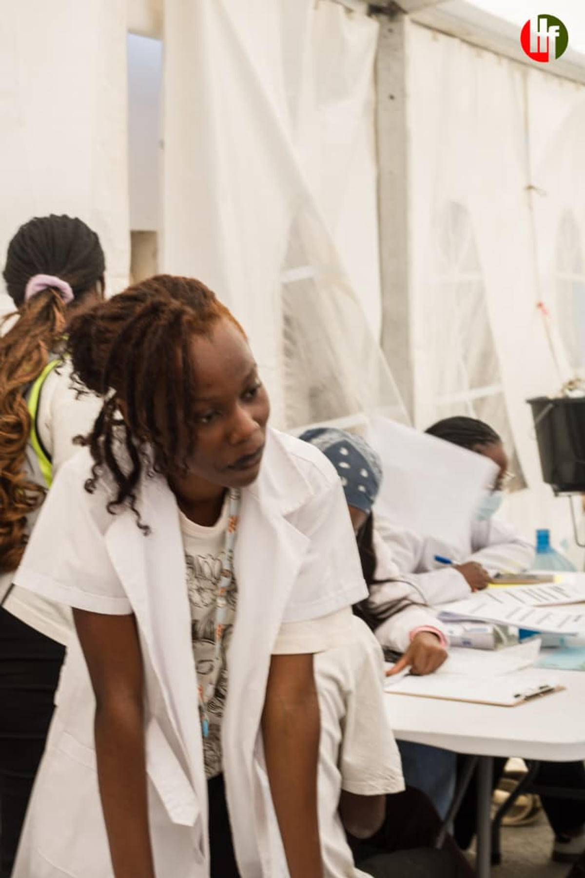 A clinician at the consultation tables inside the outreach tent