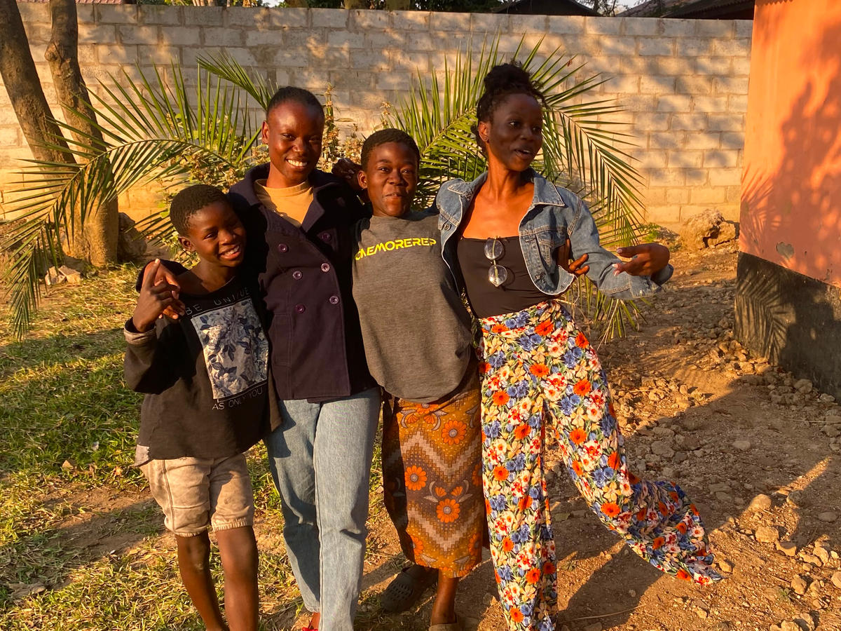 Four people smiling together outdoors