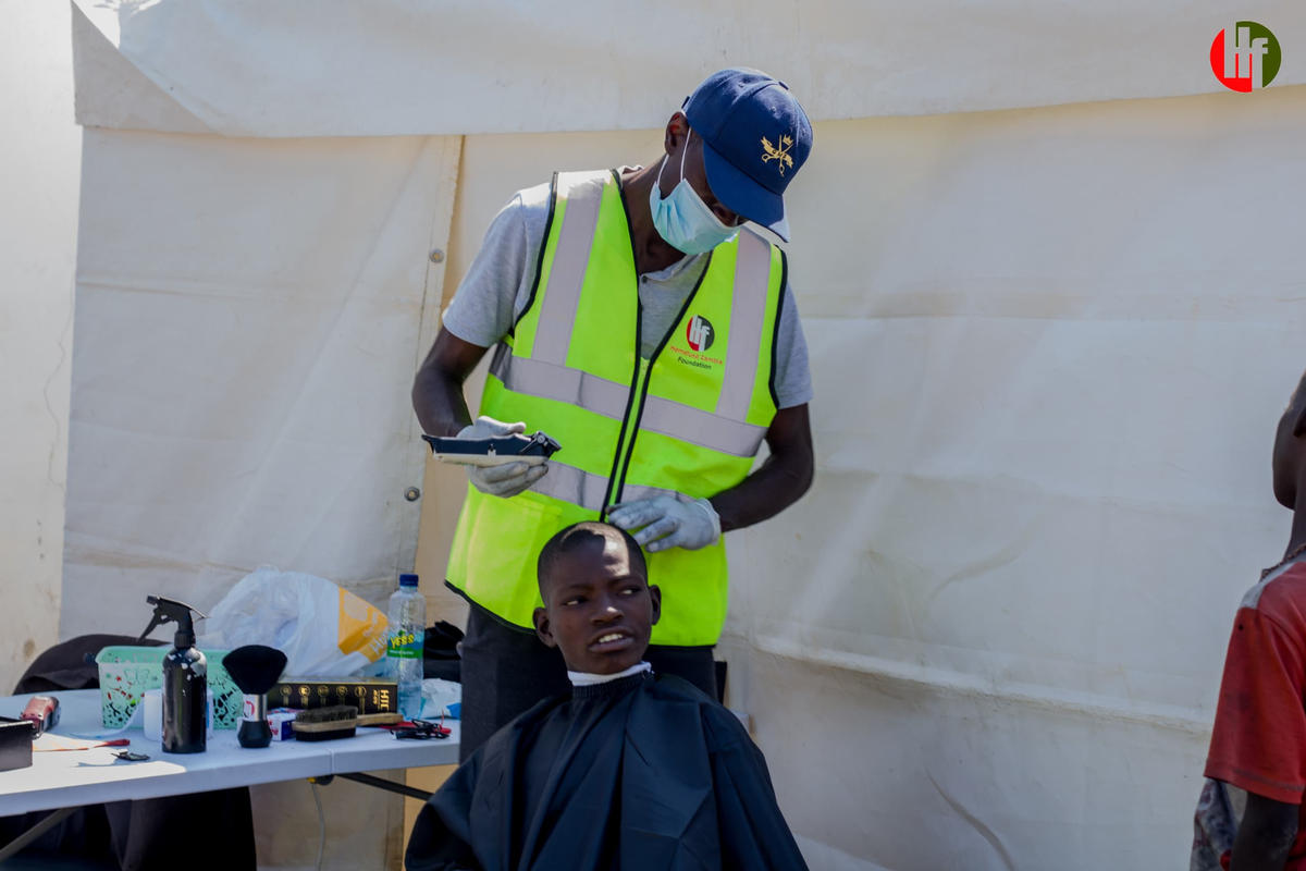 A volunteer giving a haircut during community care