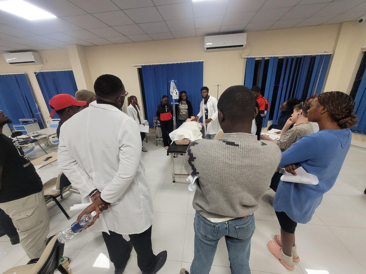 Trainees gathered around a clinical simulation station