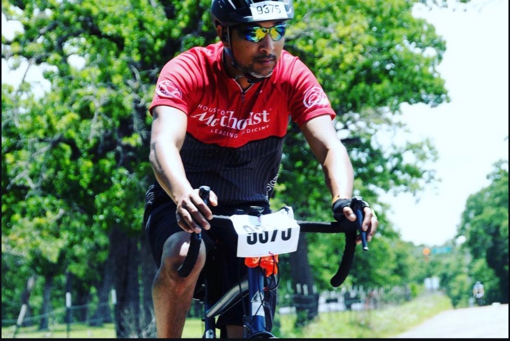 Darrance Tezino riding in a Houston Methodist cycling jersey