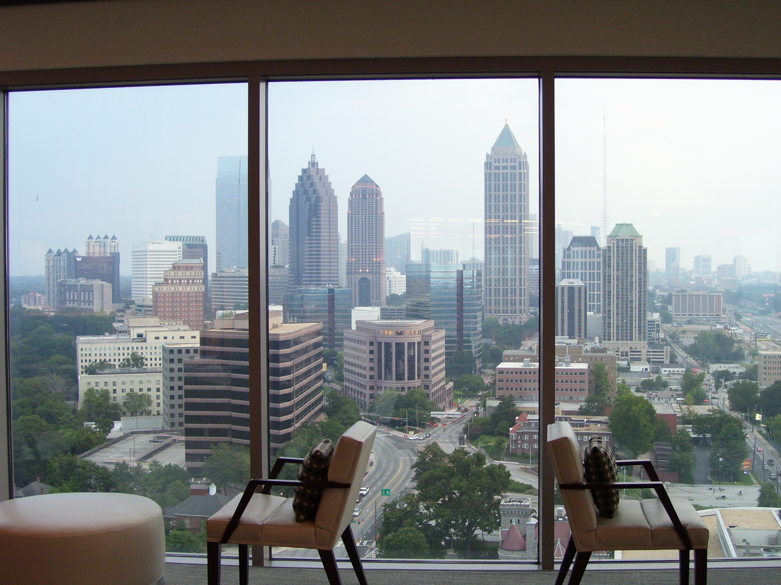 Invesco HQ integration proof, reception, executive corner offices with Atlanta skyline views, glass conference rooms, auditorium AV, video conferencing control room, codec farm server racks, and the executive workspace.