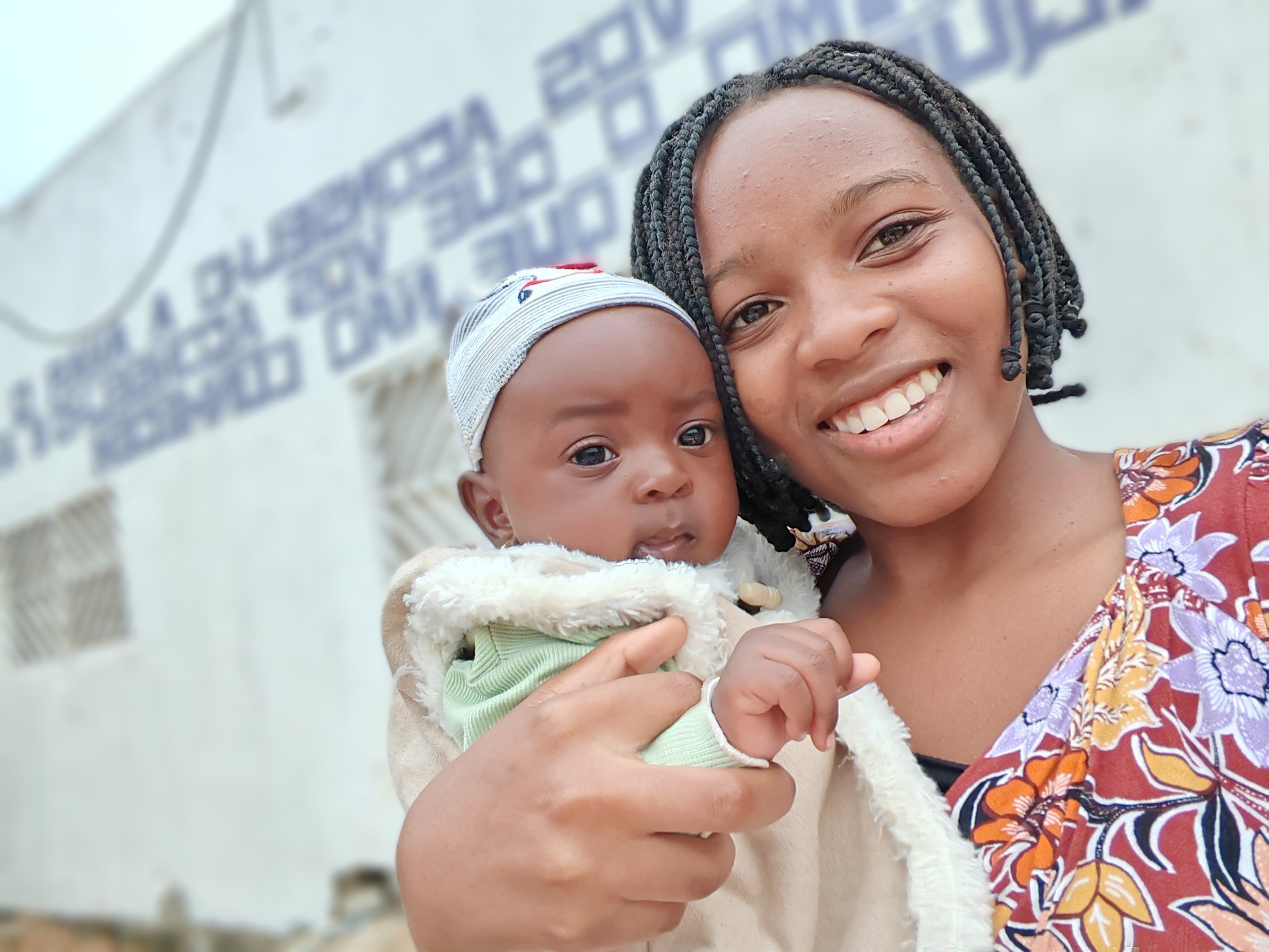 Joven madre sonriendo con su bebé en brazos en Lubango, Angola