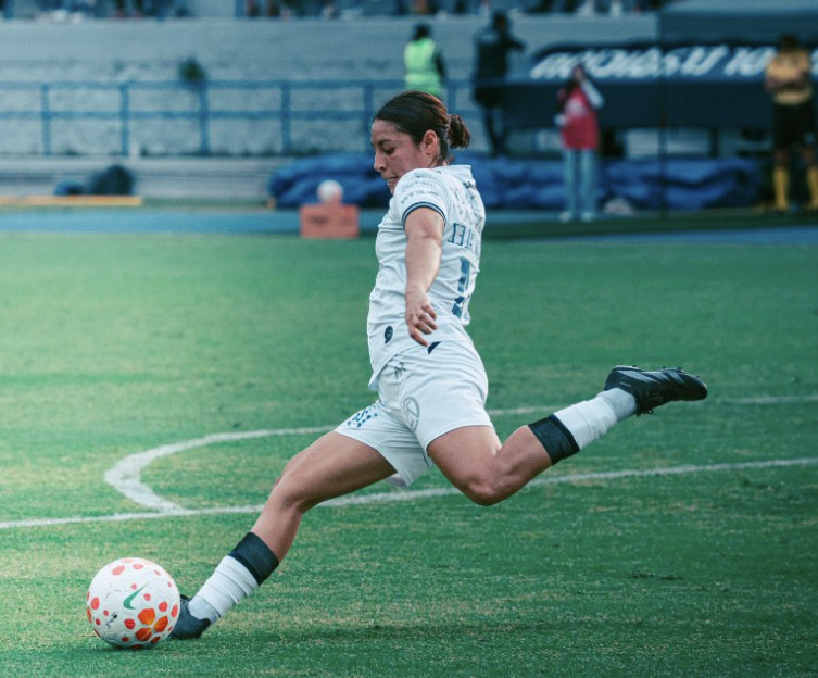 Female soccer player kicking ball