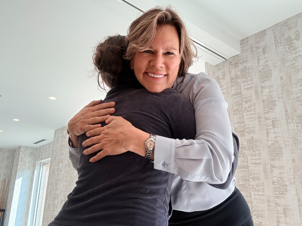 Tami giving a warm hug to a client