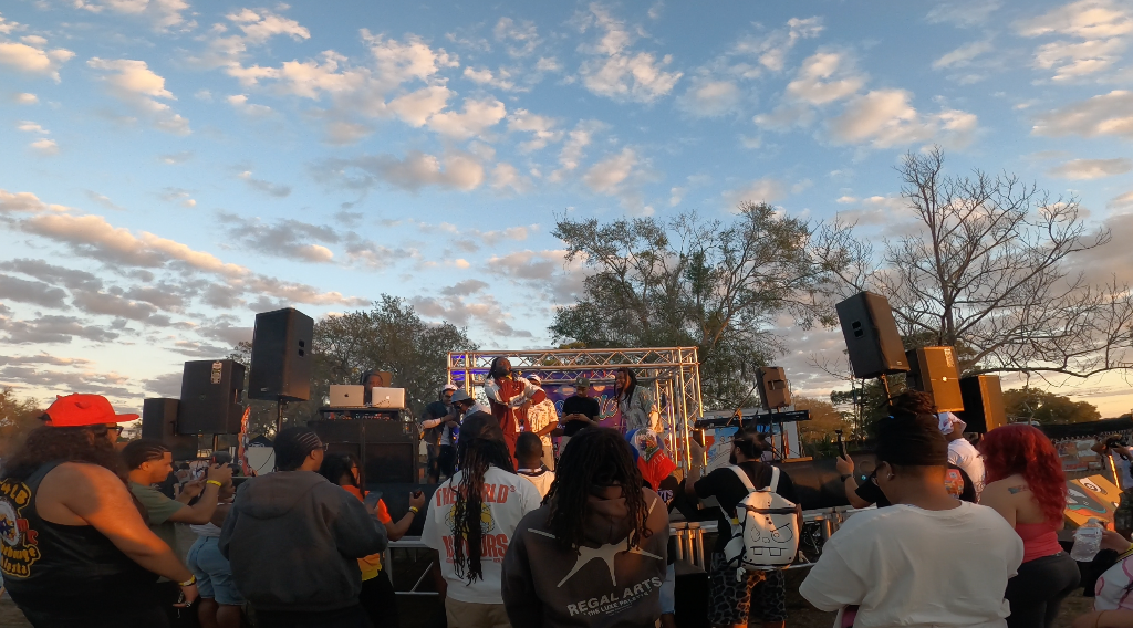 An artist performing to a lit crowd on the Droville stage