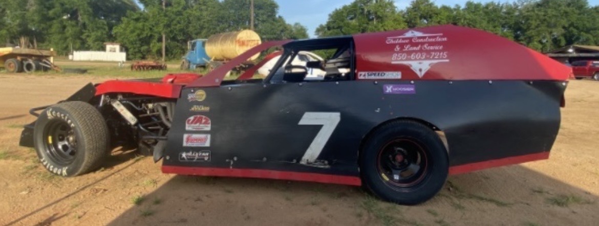 David's black and red #7 IMCA Modified parked on a dirt lot