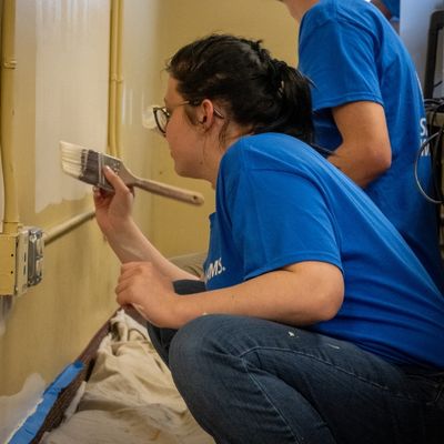 Volunteer painting a wall during a service project