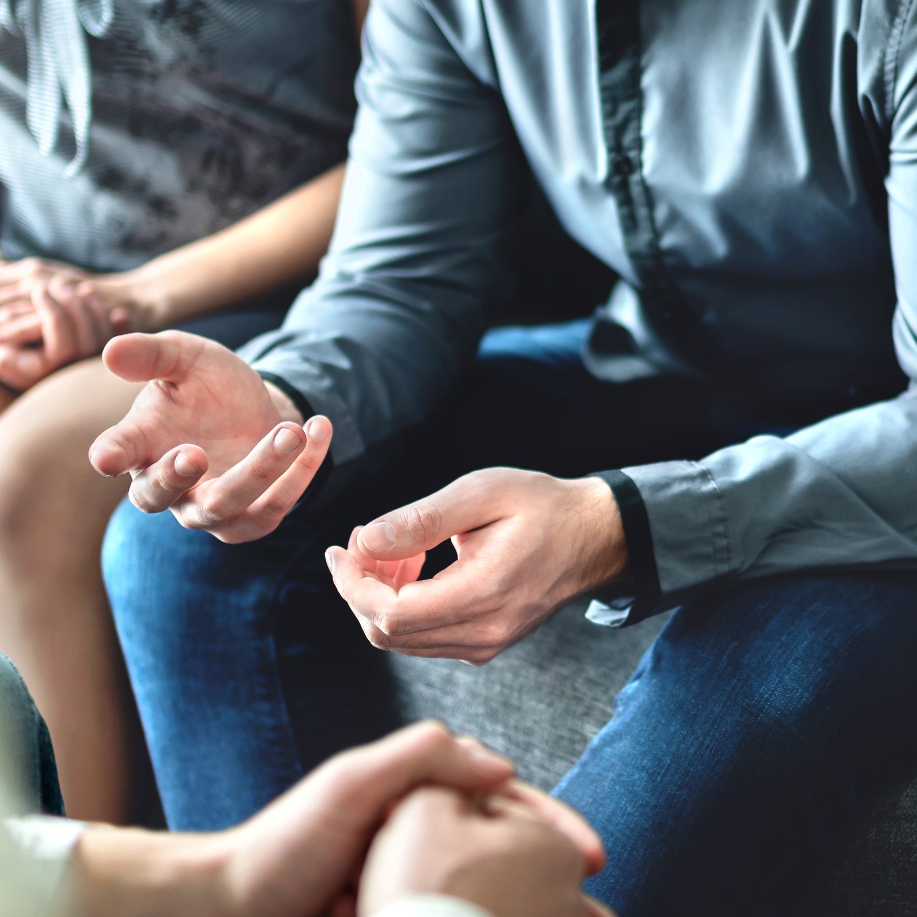 Hands of people in a support group circle