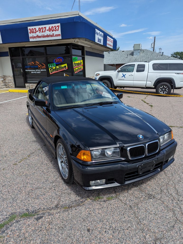 Black BMW convertible outside shop