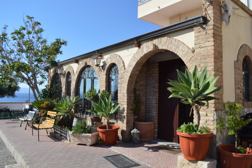 Esterno del ristorante con archi e giardino