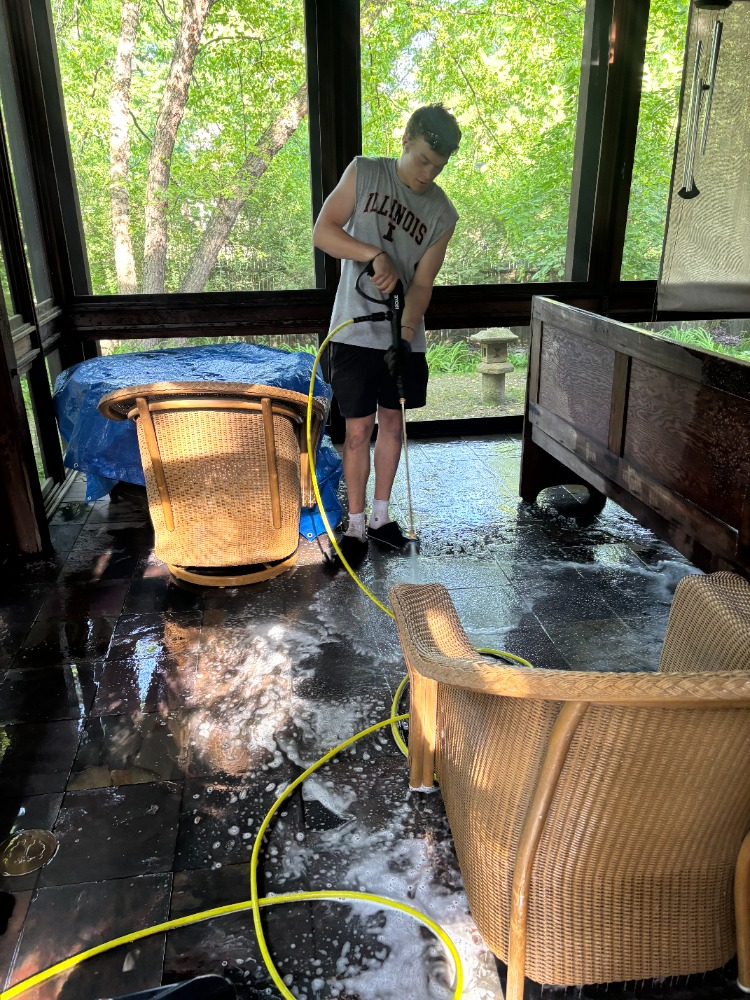 Teo power washing a screened porch floor