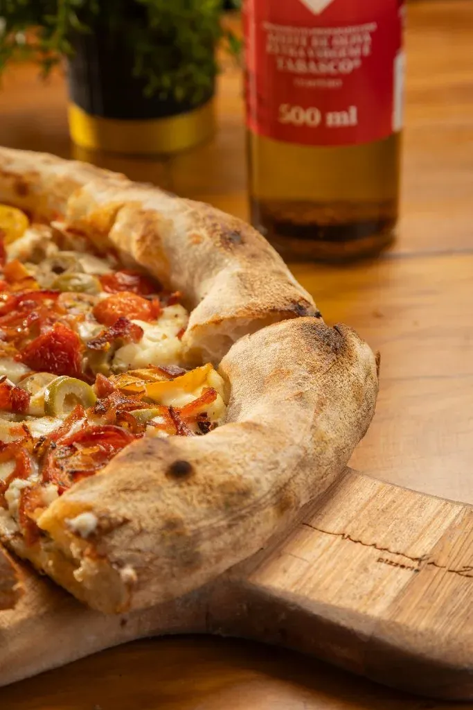 Detalhe da pizza Do Chef com queijos, embutidos e tomate-cereja, da Varanda 228.