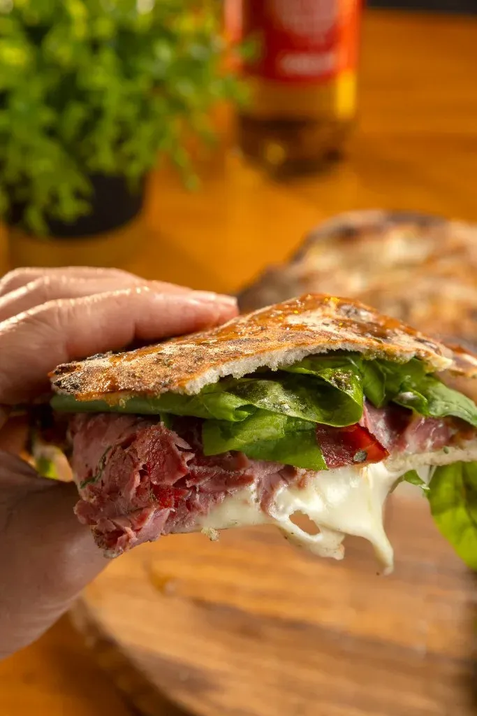 Detalhe da puccia Pastrami do Chef com queijo e rúcula, da Varanda 228.