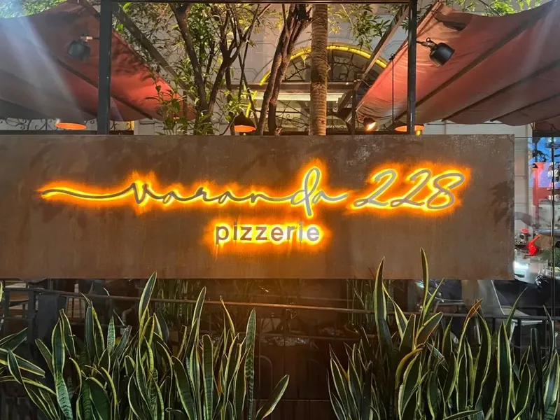 Fachada da Varanda 228 à noite, com letreiro iluminado.