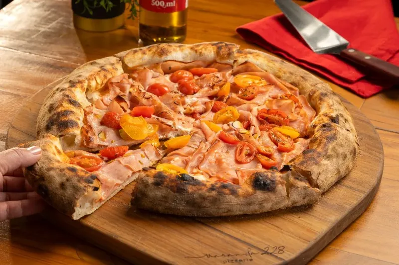 Pizza Bologna com mortadela italiana, cream cheese e tomate-cereja, da Varanda 228.