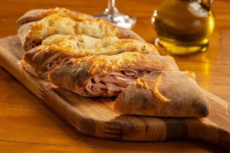 Calzone di Bologna cortado, com mortadela italiana e queijo, da Varanda 228.