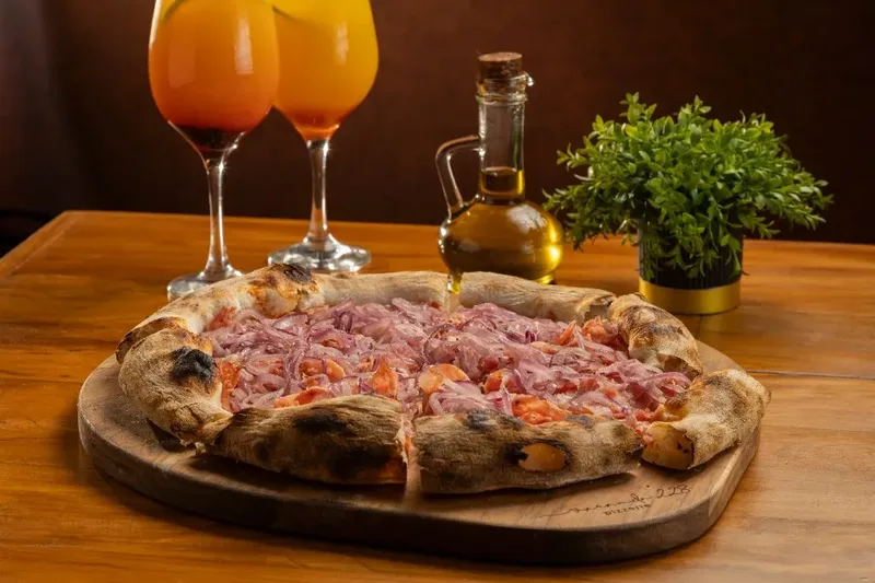 Pizza de atum com cebola sobre tábua de madeira, da Varanda 228.