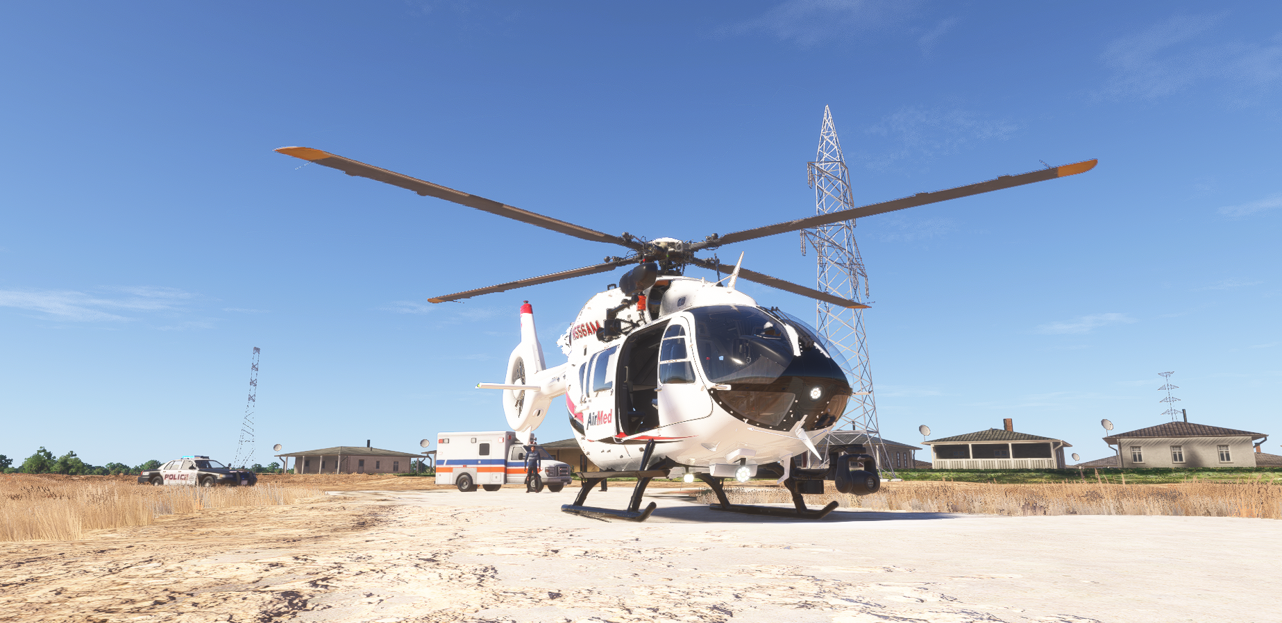 AirMed helicopter (N556AM) parked on a rural pad near power lines and an ambulance